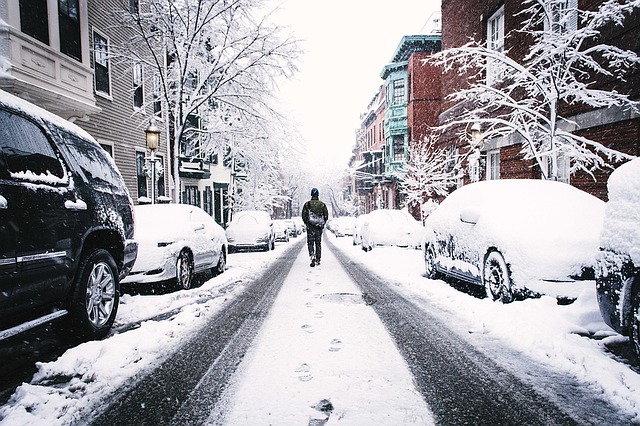 大雪が積もった道を歩く男性