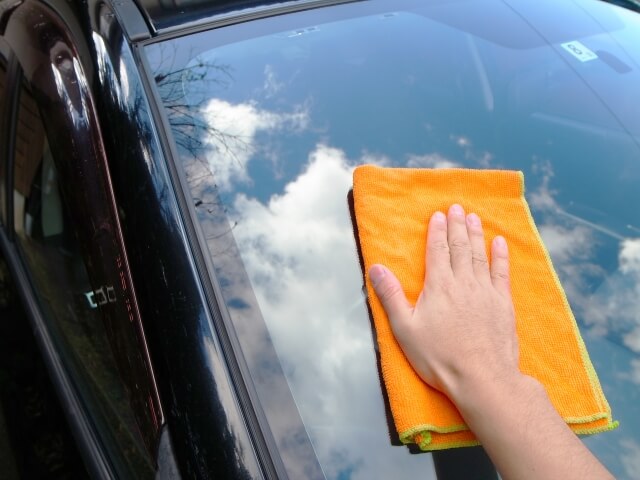車の窓を拭く手