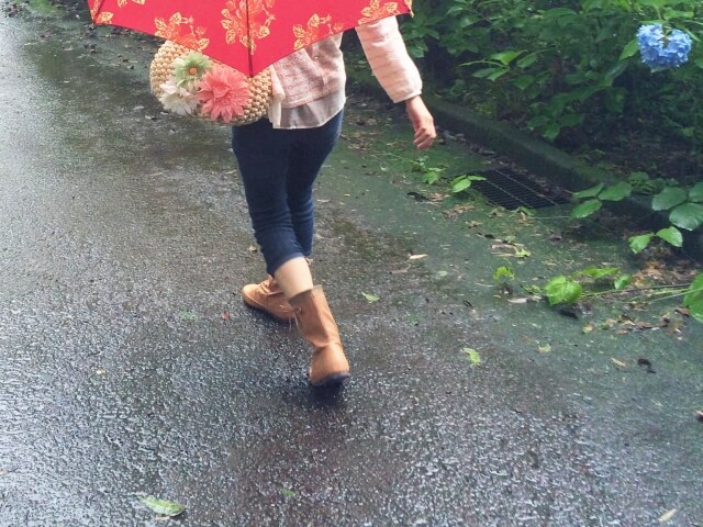 雨の日に傘をさして外を歩く女性